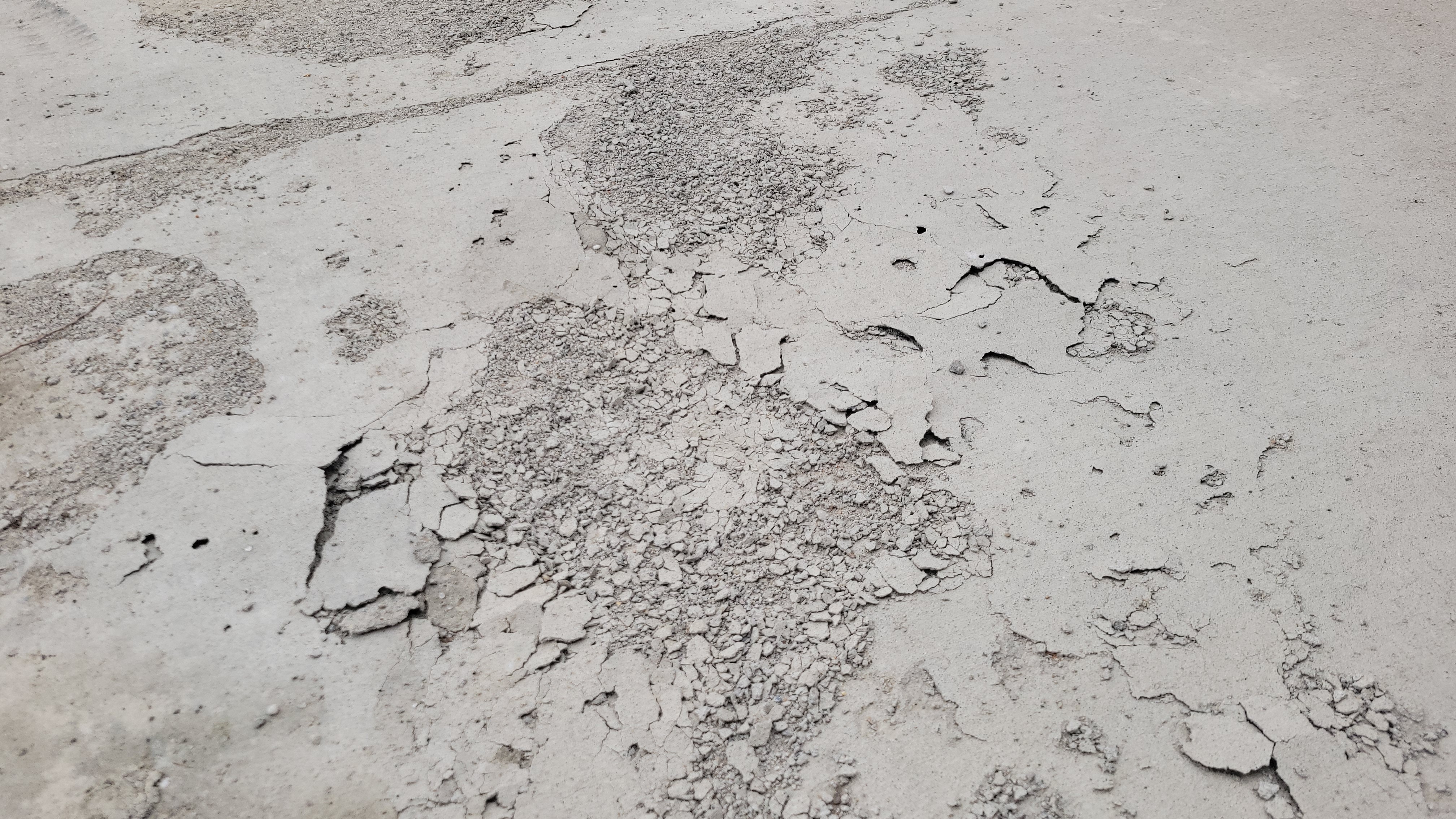 stapes concrete and grading distressed driveway